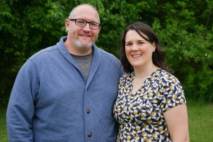 heather (grovemiller) curtis and husband pose in front of trees