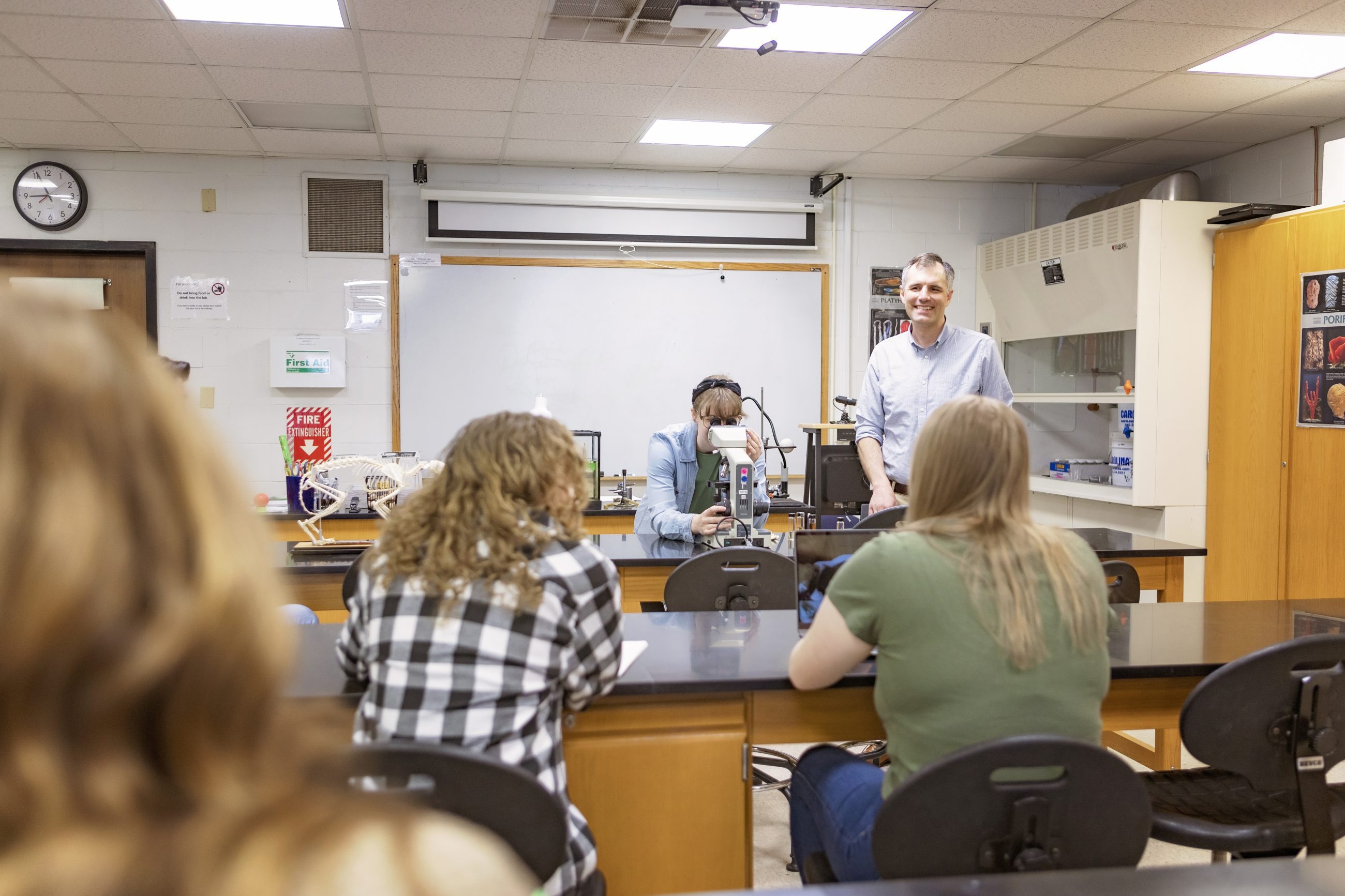 Student and teacher demonstrating use of microscope