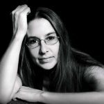 Susan Horvatis seated with her head propped by her right arm