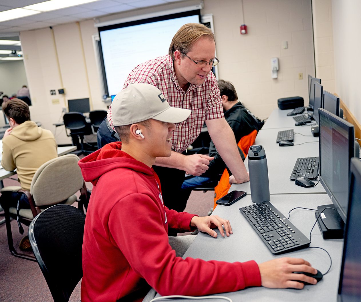 Shawn Campbell assisting male student in computer lab