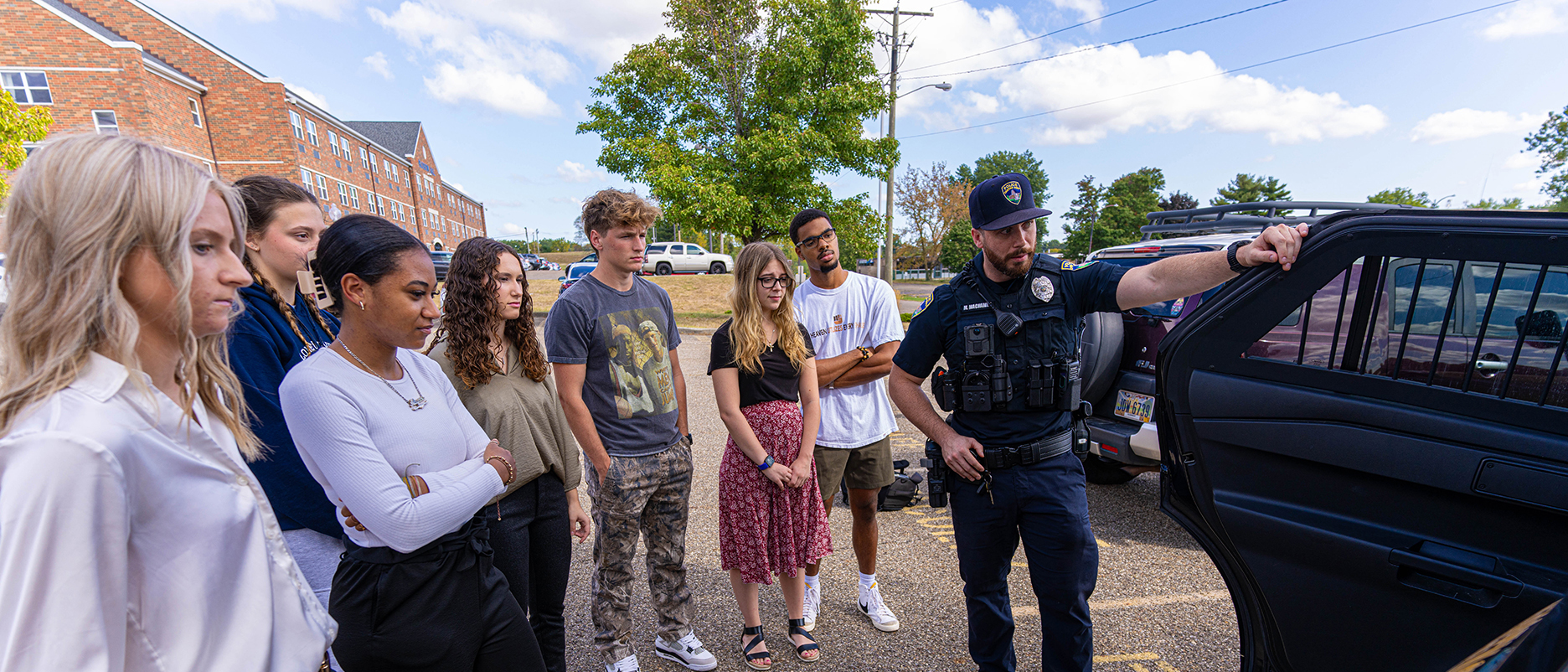 police officer showing interior of vehicle to group of 7 students