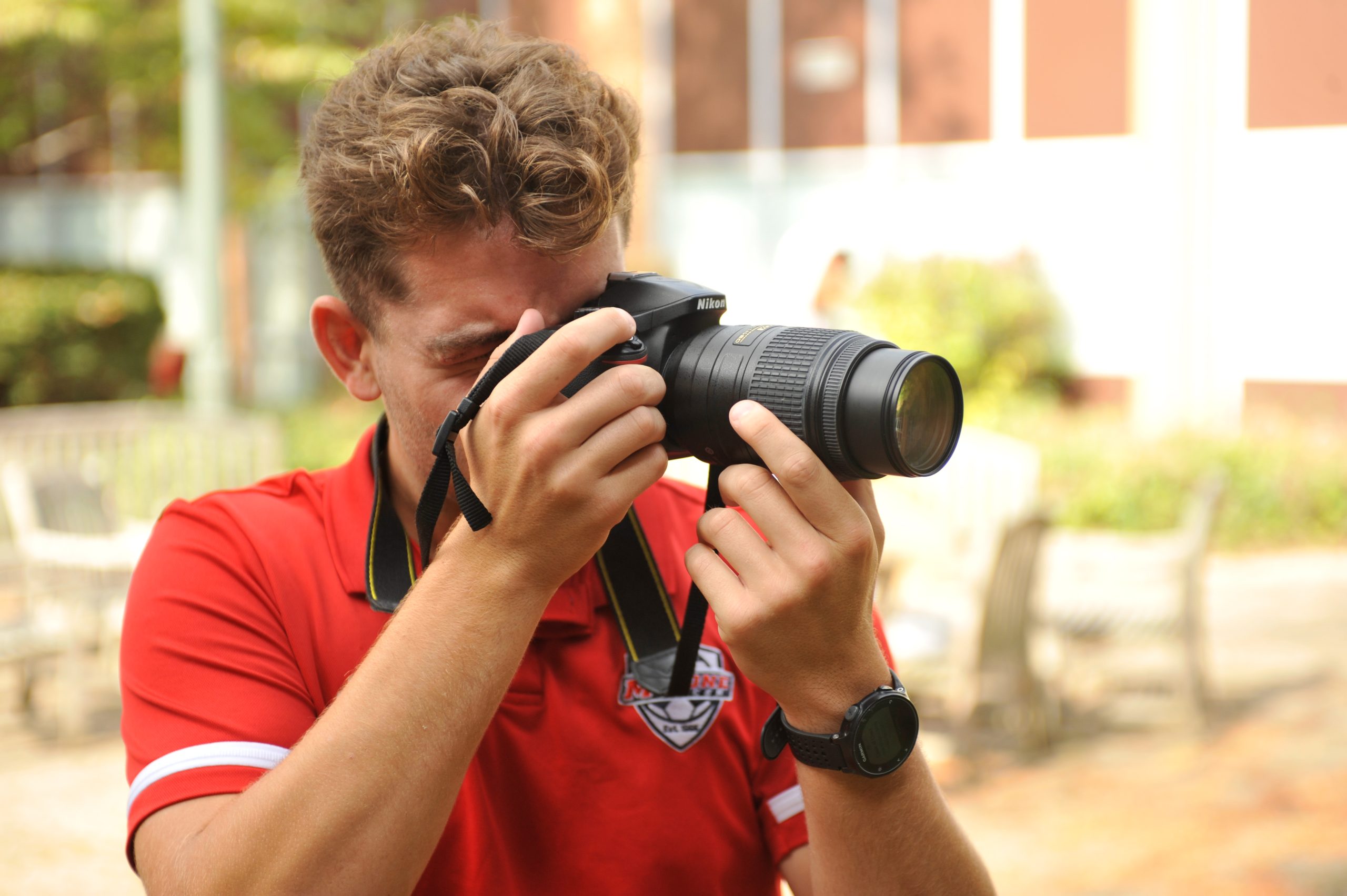 male student focusing a Nikon camera
