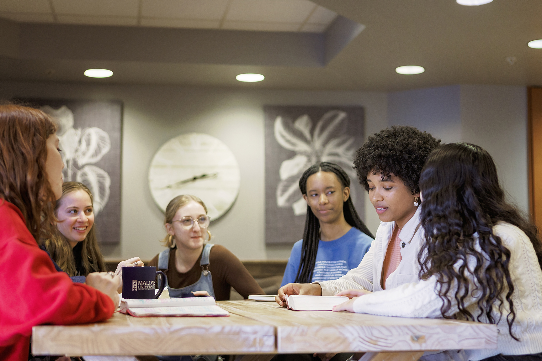 6 women of various ethnicities seated around a table