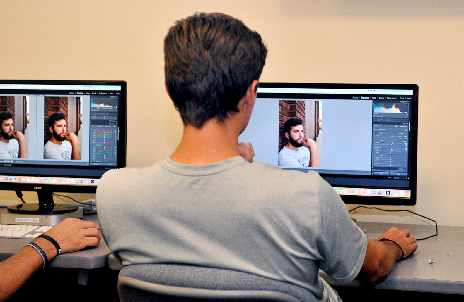 backside of male student seated in front of a computer screen