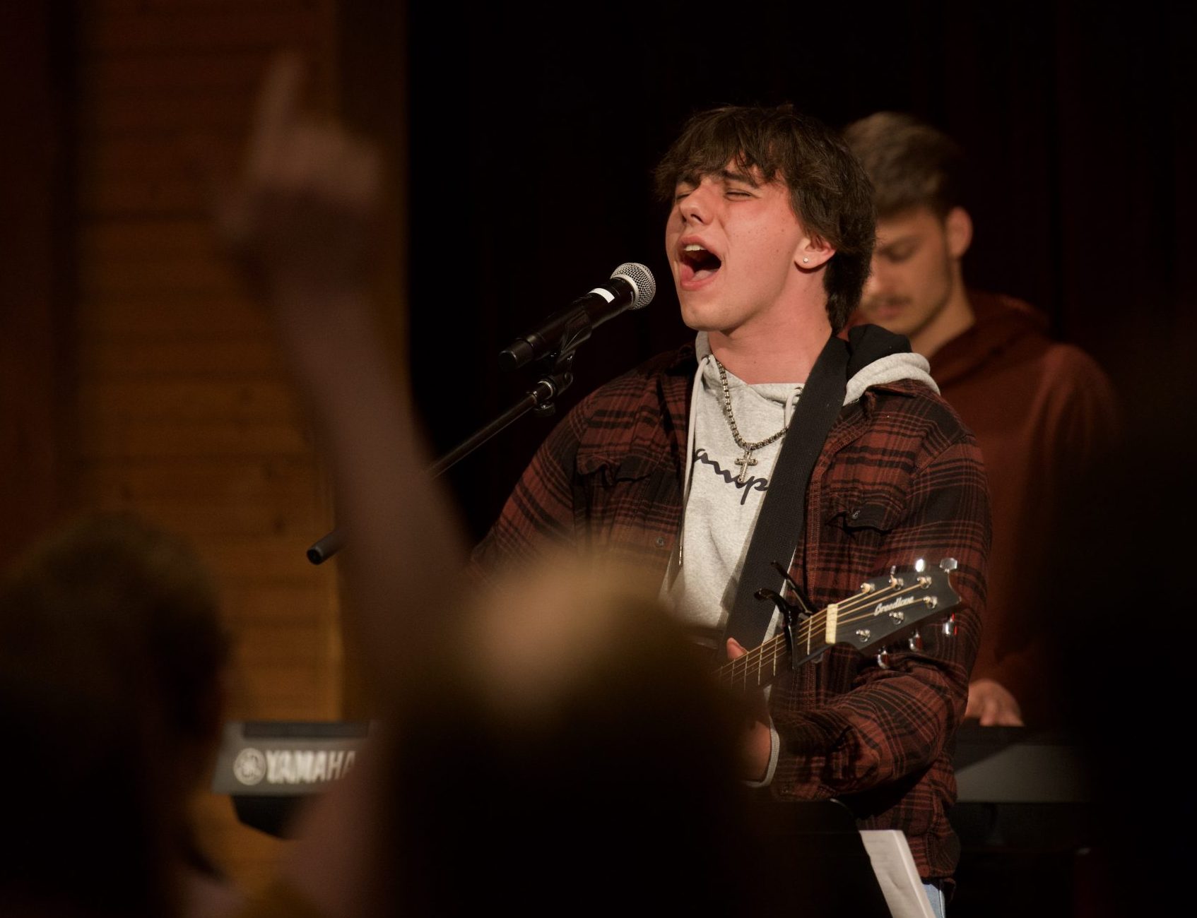 male singer with guitar, another male behind him