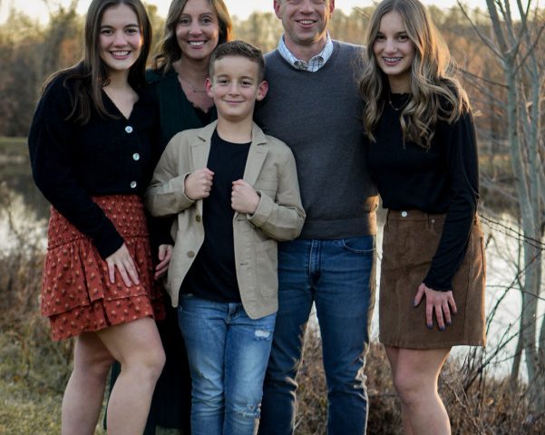 Julian Coblentz and his family standing in front of a pond
