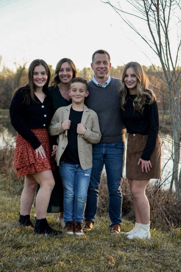 Julian Coblentz and his family standing in front of a pond