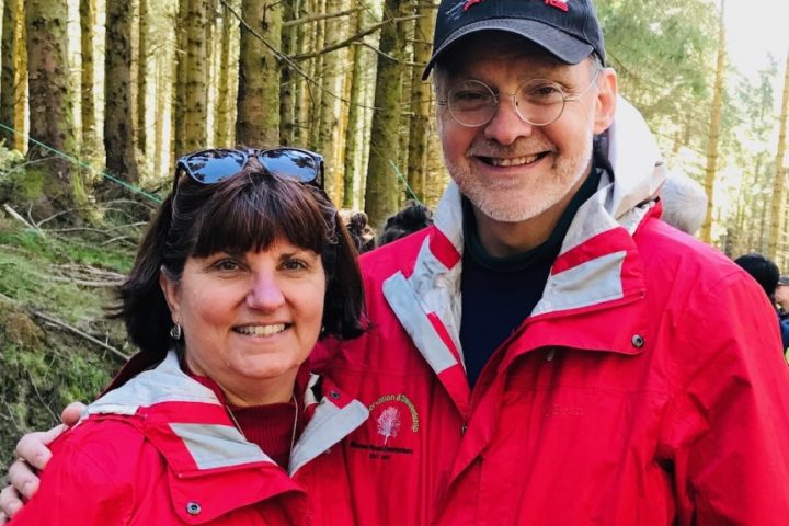 Jim and Heidi Gresh posing in front of timberland