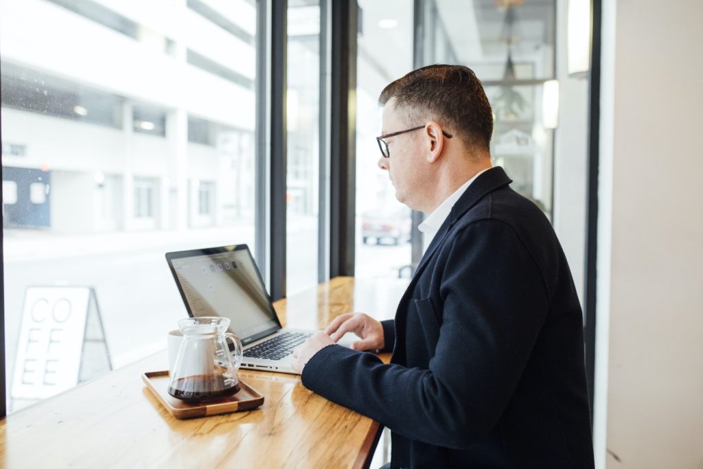 Businessman conducting work on a laptop in a coffee shop.