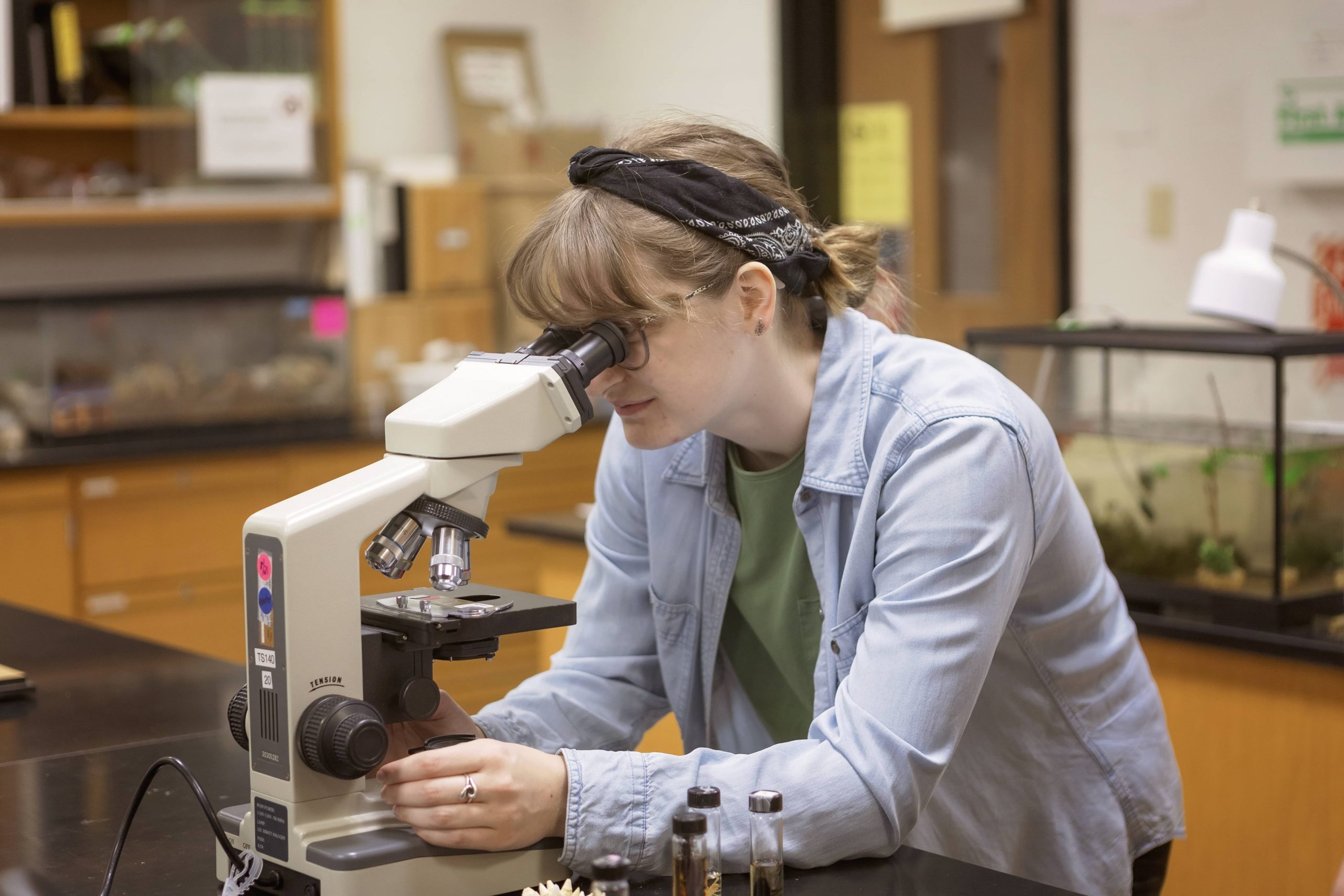 female student looking into a microscope