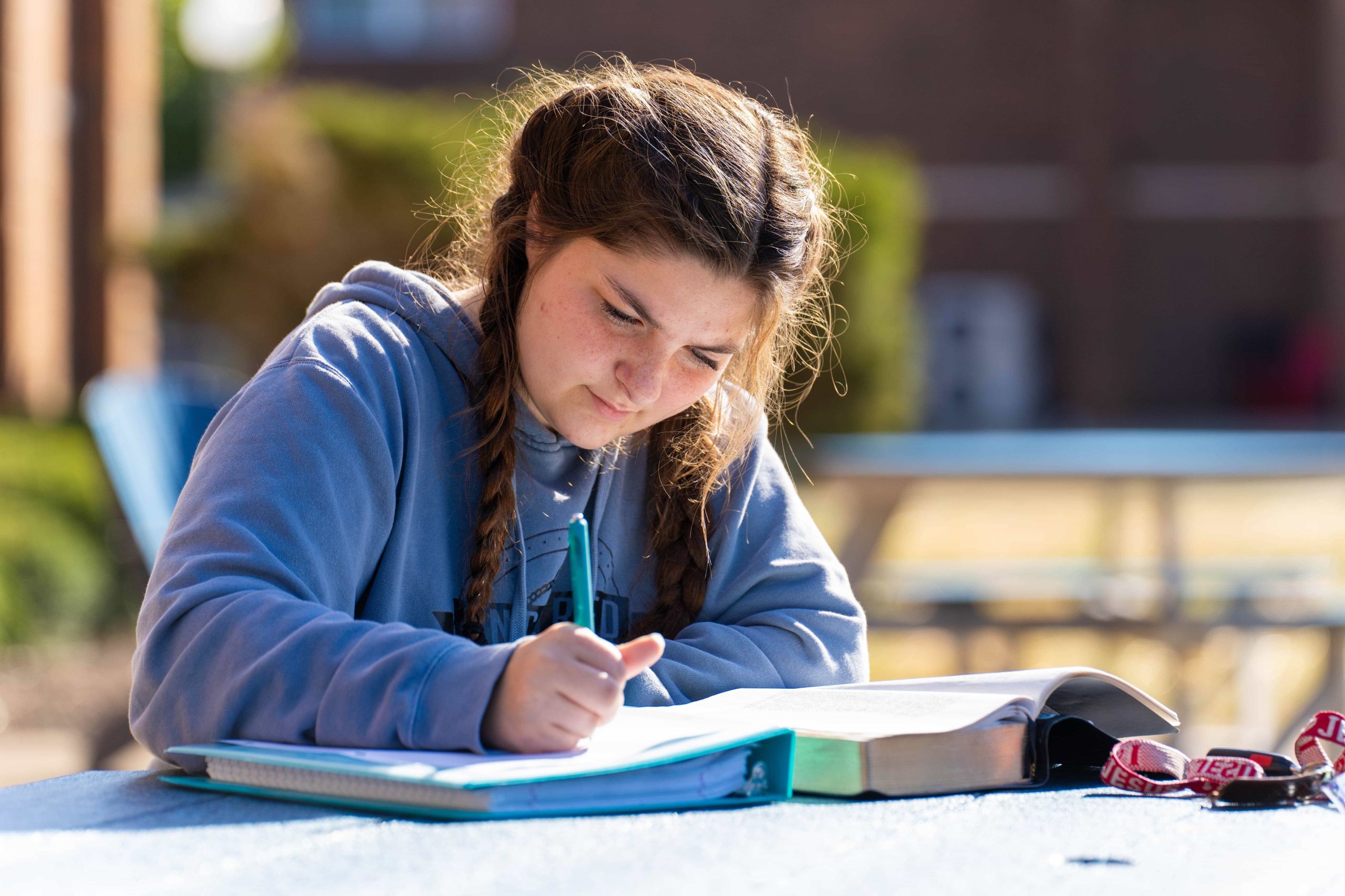 close-up front view of female student studying at outdoor table
