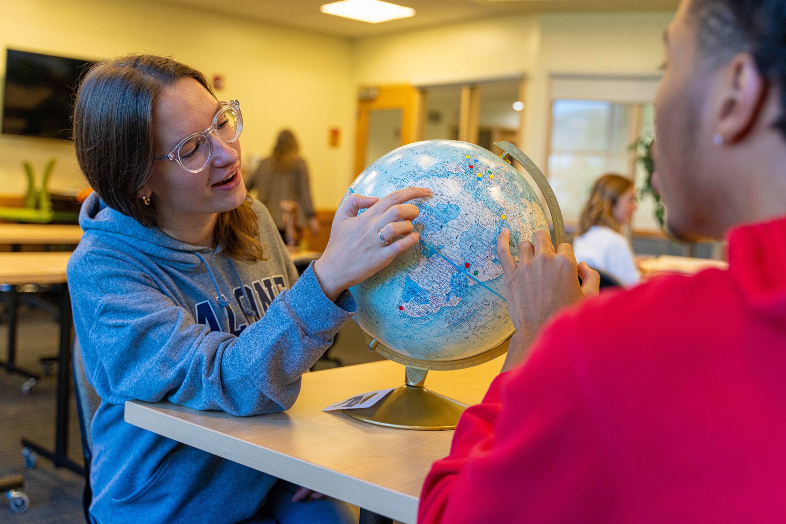 2 students examining a globe of the world