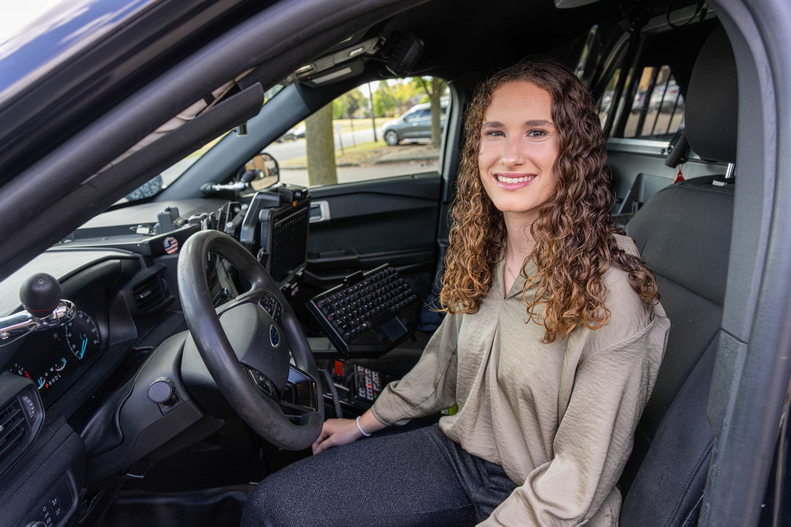 female student seated inside a police vehicle