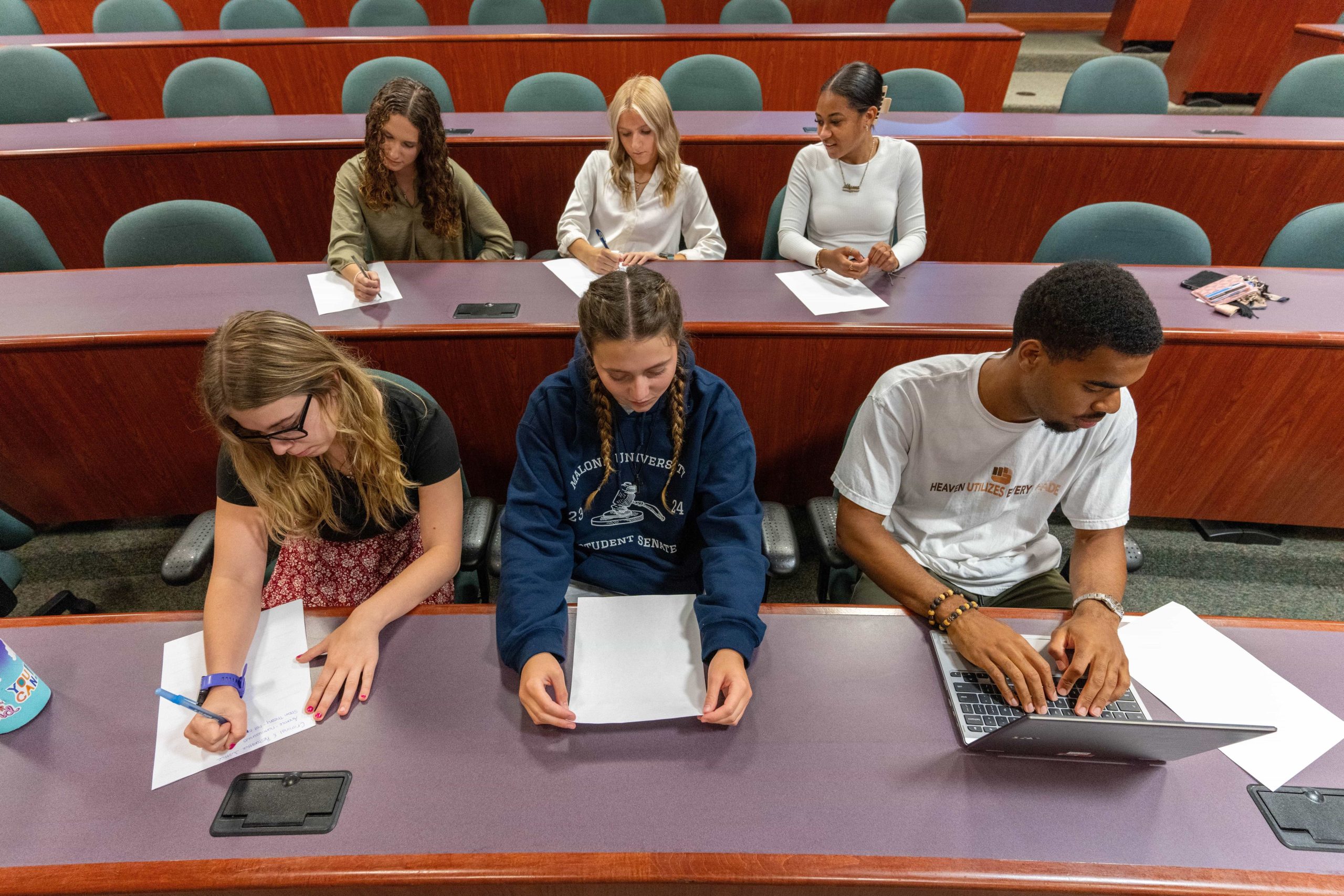 2 rows of 3 students seated in Silk Auditorium doing classwork_1