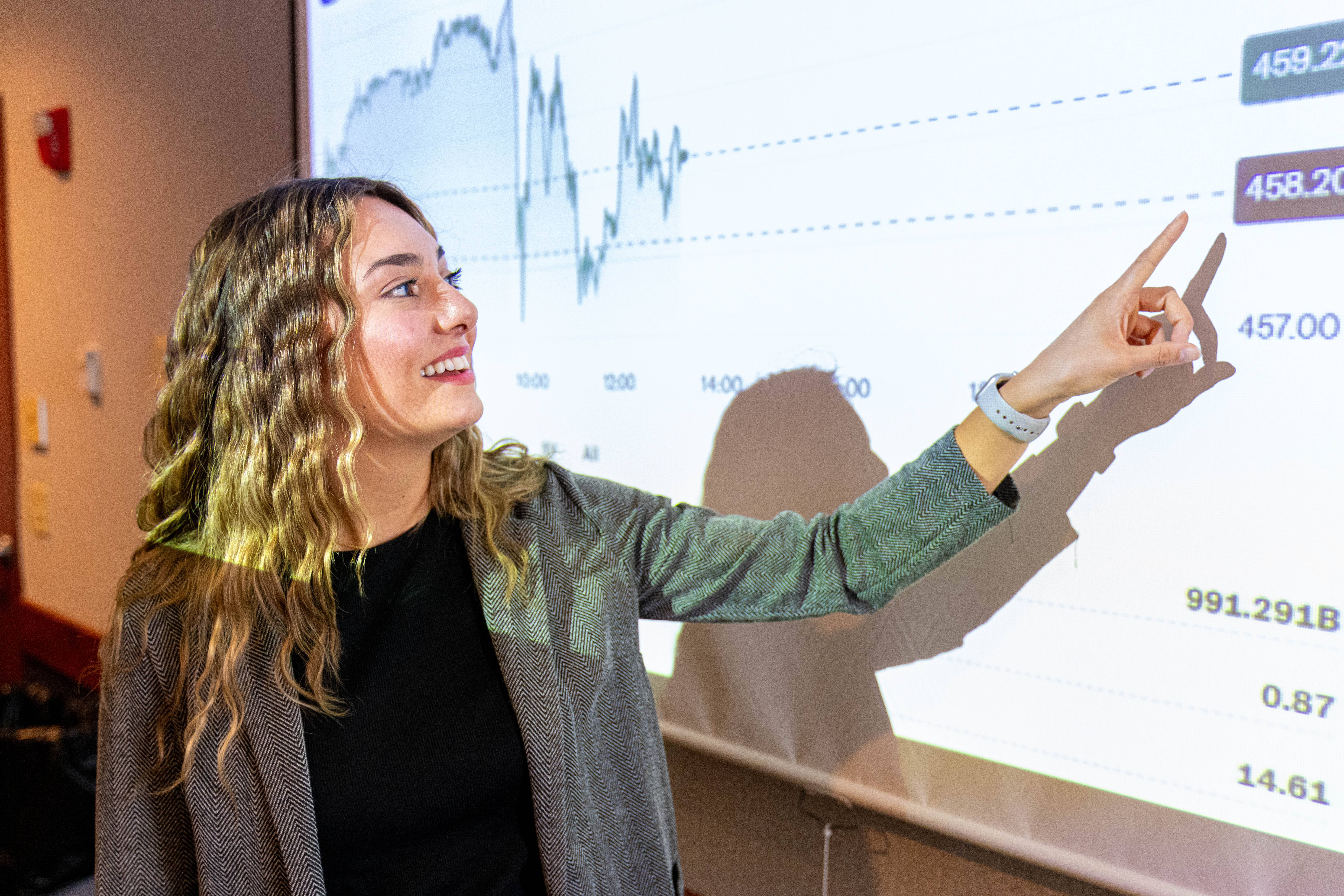 woman pointing to a chart on a screen