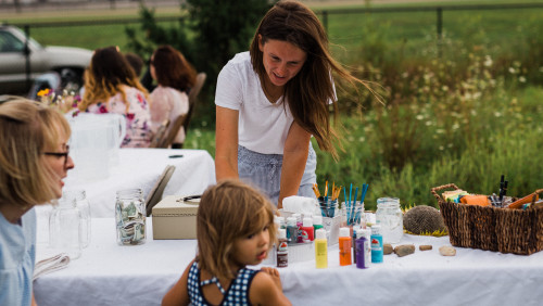 Jillian Humphrey leaning over table of craft supplies with little girl across from her