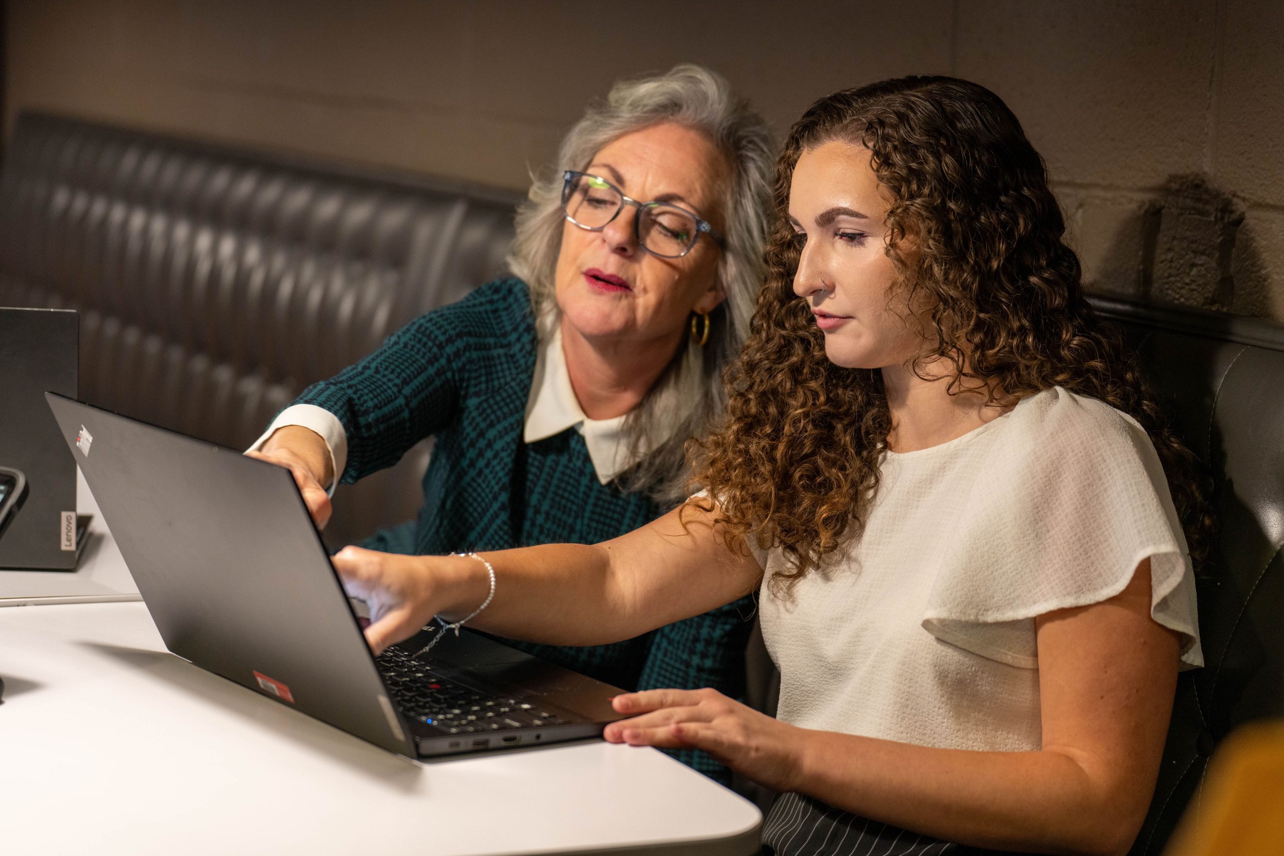 professor and student looking at a lap top screen