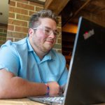 male student working on lap top