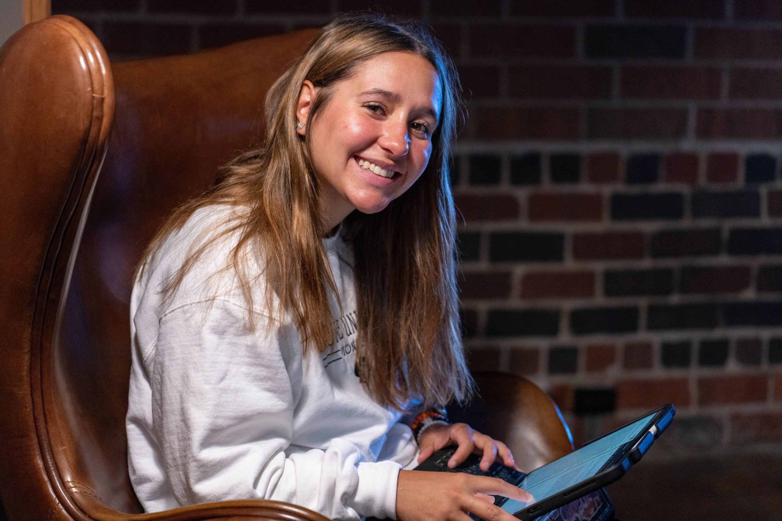 female student sitting in a chair with her laptop