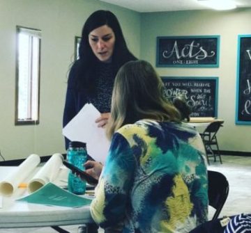 Sarah Keene '09, '15 facing a seated female at table